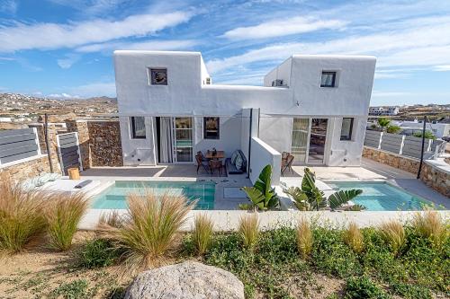 克洛瓦斯Le Palme Mykonos的一座白色的房子,前面设有一个游泳池
