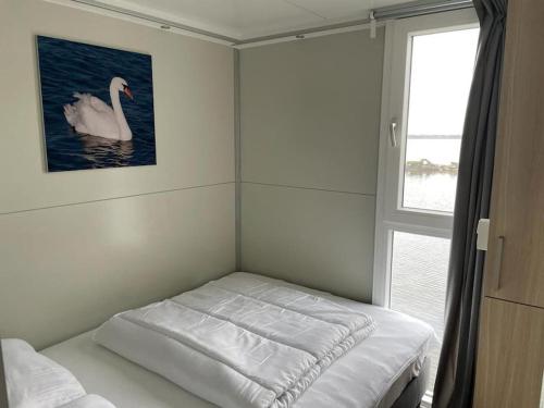 比丁赫伊曾Houseboot Cormorant, lake view的一间房间,配有一张天鹅图案的床