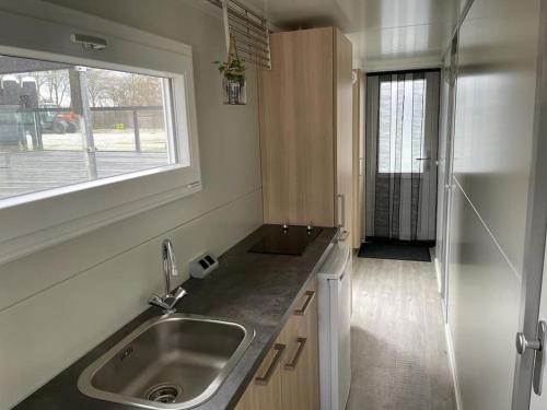 比丁赫伊曾Houseboot Cormorant, lake view的一个带水槽和窗户的小厨房