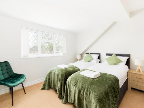 利明顿温泉Pass the Keys Self Contained 2 Bed with Parking Leamington Spa的卧室内的两张床,配有绿色椅子