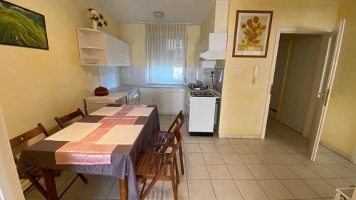 考波什堡Orange Apartman的厨房配有桌椅和冰箱。