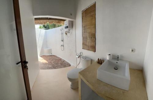 LembarKhabita Beach Resort的白色的浴室设有水槽和卫生间。