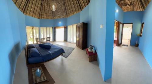 LembarKhabita Beach Resort的蓝色的房间,中间有一张床