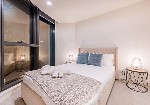 墨尔本Stylish Urban Oasis的一间卧室设有一张大床和一个大窗户