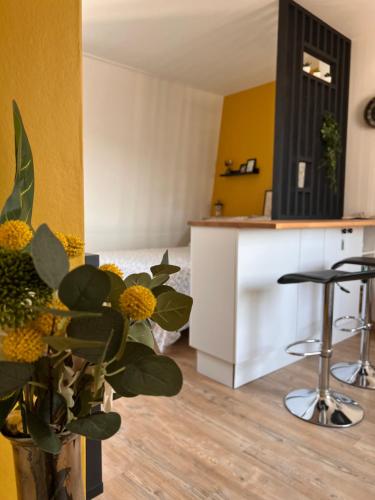 里尔Le Jean Bart - Lille的厨房设有黄色的墙壁和带凳子的柜台。