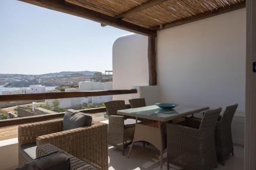 奥诺斯Amaris Mykonian Residence的阳台的用餐室配有桌椅
