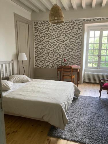 Les Tourellières的一间卧室配有一张床和一张书桌