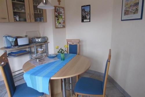 萨尔堡Ferienwohnung Wilhelmi的一张桌子和椅子,上面有蓝色的桌布