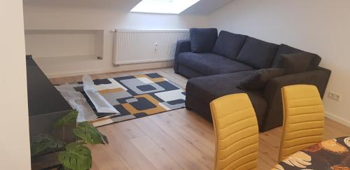 施韦青根Joanna Apartment - Schwetzingen 3的客厅配有蓝色的沙发和黄色的椅子
