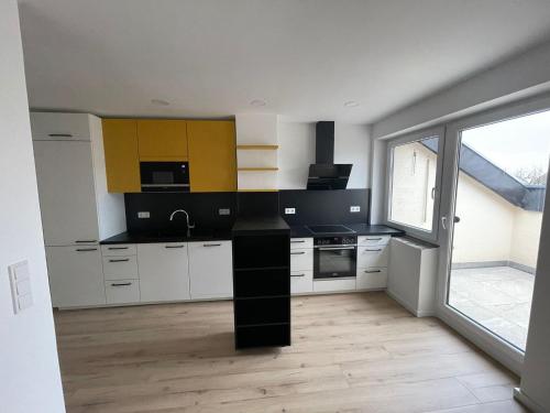 施韦青根Joanna Apartment - Schwetzingen 3的厨房配有白色橱柜和黑色台面