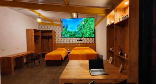 坎波斯杜若尔当金色森林普萨达酒店的客房设有两张床和一张桌子上的笔记本电脑