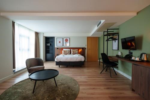 迪南莫里尼花园酒店的酒店客房带一张床、一张桌子和椅子
