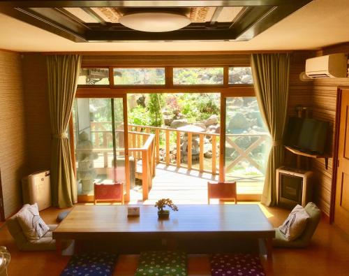 小樽Garden House Umenoya Otaru的客厅设有桌子和大窗户