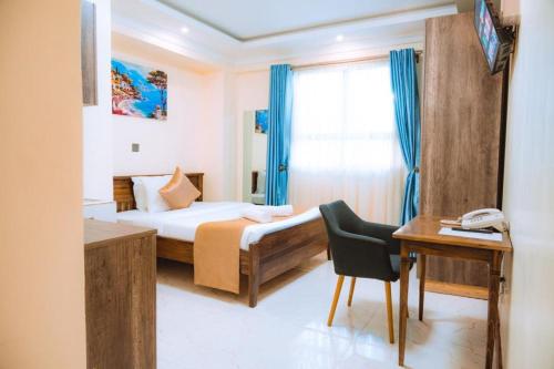 内罗毕Kije Place Hotel的酒店客房配有一张床和一张带电脑的书桌