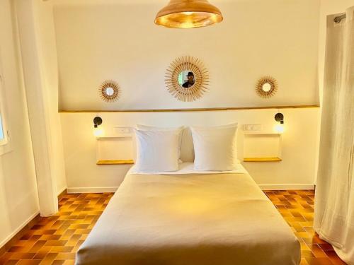 格雷乌莱班Gite Harmonie的一间卧室配有一张带白色枕头和镜子的床