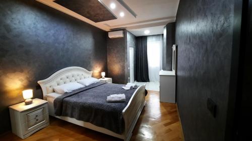 库塔伊西Makos Guest House的一间卧室配有一张床、两盏灯和一个窗户。
