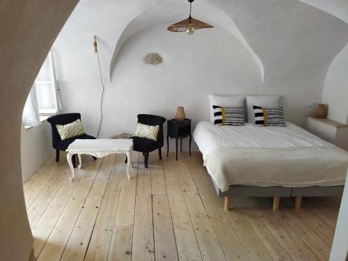 屈屈龙Les Chambres De Charlotte的卧室配有一张床和一张桌子及椅子