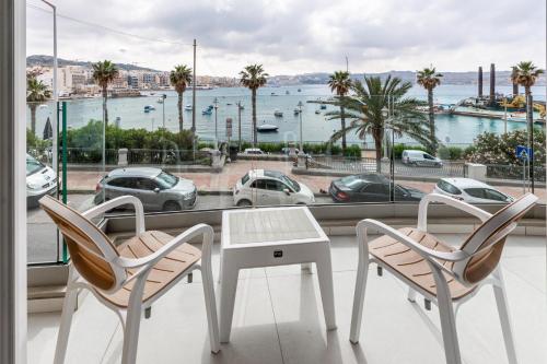 圣保罗湾城Seafront Luxury Apartment的一张桌子和两把椅子,享有海港的景色