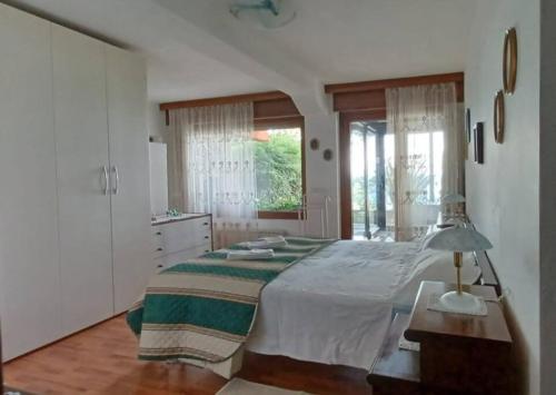 的里雅斯特Brezza Marina - Appartamento in villa fronte mare的一间卧室设有一张大床和一个窗户。
