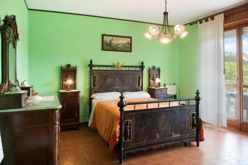 Cisterna dʼAstiAppartamento Glicine的一间卧室设有一张床和绿色的墙壁