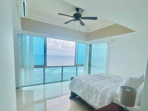 圣多明各Beach Front Penthouse in Exclusive Tower的一间卧室配有一张床和吊扇