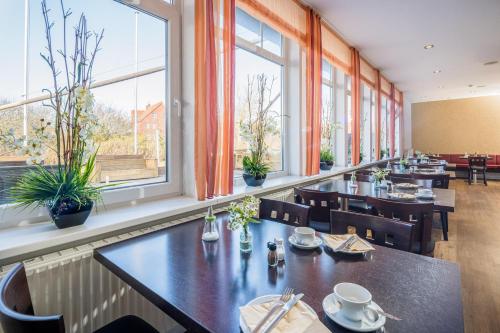朗格奥阿彻特迪克斯特瑞德酒店的餐厅设有桌椅和窗户。