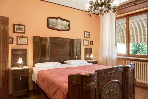 Cisterna dʼAstiClematis的一间卧室配有一张大床和木制床头板