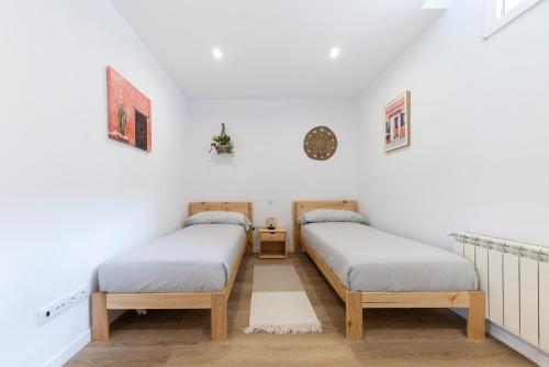 奥维多Apartamento con Jardín en el Oviedo Antiguo的白色墙壁客房中的两张单人床