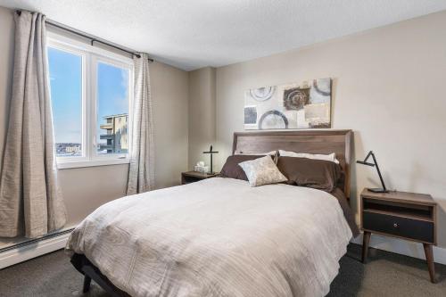 萨斯卡通Superb 2 bedroom downtown with river view的一间卧室设有一张床和一个大窗户