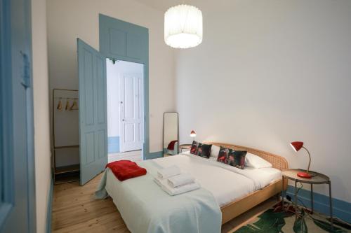 波尔图Adorable Apartments in Great Area的卧室配有白色大床和灯