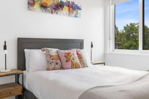 墨尔本South Yarra apartment with stunning views的白色卧室配有带枕头的床和窗户