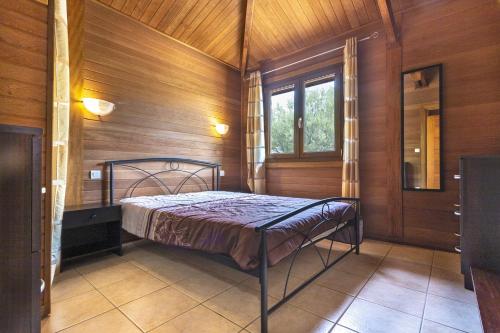 菲加里Petite Maison En Bois Exotique的卧室配有一张床铺,位于带木墙的房间内