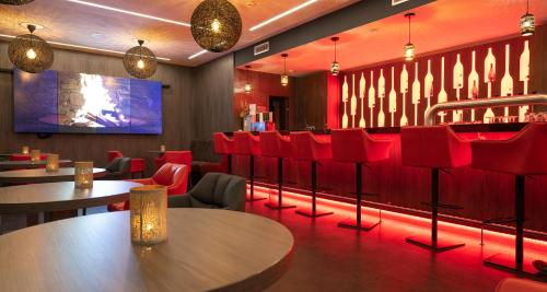 曼海姆Best Western Plaza Hotel Mannheim的餐厅设有红色的桌椅和屏幕