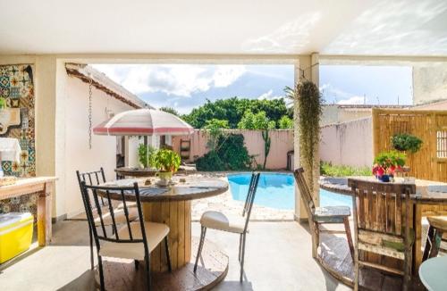 布拉干萨-保利斯塔Pousada Bem te vi的一个带桌椅的庭院和一个游泳池