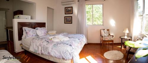 Santo CerroHotel Santo Cerro Natural Park的卧室配有床、椅子和窗户。