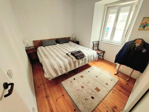 里斯本Cosy Apartment in Central Lisbon的一间卧室配有一张带地毯的床和窗户