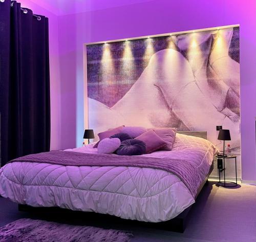 ArçaisDomaine de l'Angélique - Loft avec SPA privatif - Marais poitevin entre Niort et La Rochelle的紫色卧室,配有一张带大床头板的床