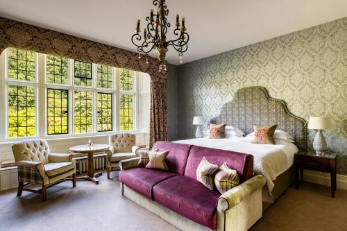 莫顿汉普斯泰德博维城堡酒店的一间卧室配有一张大床和一张紫色沙发