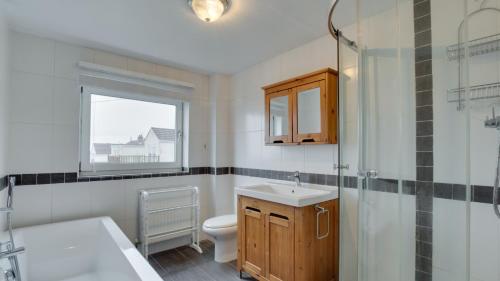 马伯斯Woodville Road, Mumbles的浴室配有卫生间、盥洗盆和淋浴。