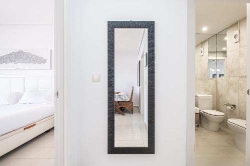 贝尼多姆Gemelos 26 Resort Apartment 27C Levante Beach的卧室配有镜子,设有床和浴室