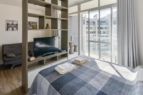 圣保罗Flat Completo na Ponte Estaiada SP的一间卧室设有一张床、一台电视和一个窗口。