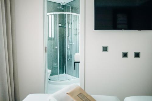 里斯本Next Level Premium Hotels的带淋浴的浴室和玻璃门