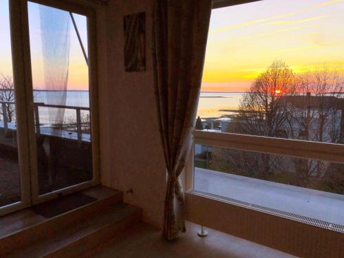 哈普萨卢Sunset Dream Apartment with a panoramic seaview的客房设有可欣赏日落美景的窗户。
