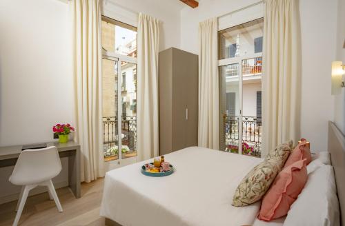 锡切斯Antonios Hostal的卧室配有一张床、一张书桌和窗户。