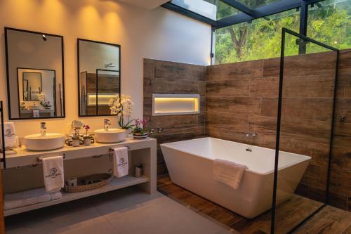 伊泰帕瓦Saison Resort & Spa的浴室配有两个盥洗盆和浴缸。