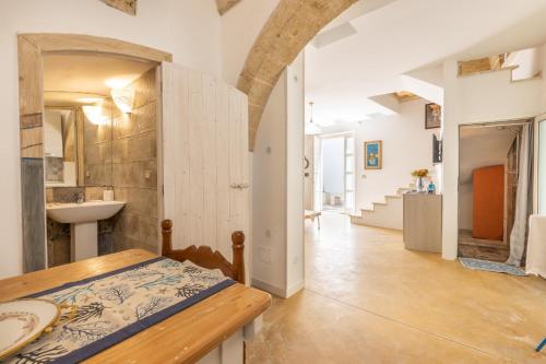 拉卡莱Dimora il Castello的一间设有桌子和水槽的客房以及走廊