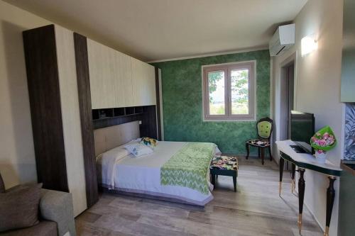 Crespinaappartamento Margherita的一间卧室设有绿色的墙壁、一张床和一张书桌