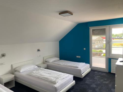 卡佩尔-格拉芬豪森Ferienwohnungen zur Elz的一间卧室设有两张床和蓝色的墙壁