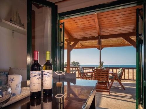 古瓦伊Mayia Sunset sea front house Gouves Heraklion的一间房间,桌子上放有两瓶葡萄酒