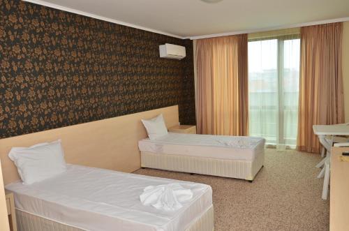 普里莫尔斯科La Piazza Primorsko Rooms & Apartments的酒店客房设有两张床和窗户。